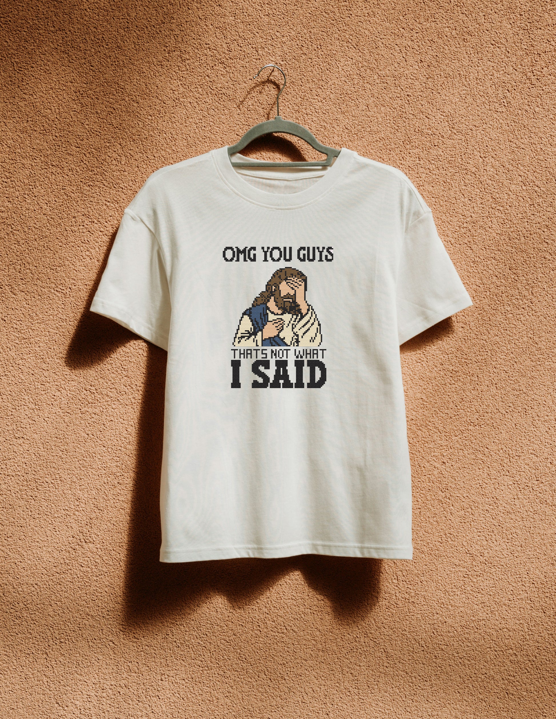 White t-shirt with graphic design and text on a beige background