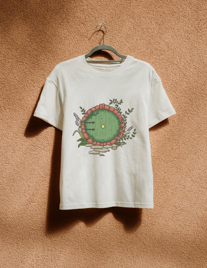 White t-shirt with a circular design hanging on a hanger against a textured brown wall.