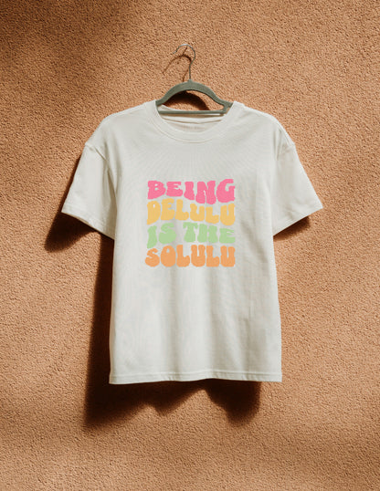 White t-shirt with colorful text on a hanger against a brown textured wall