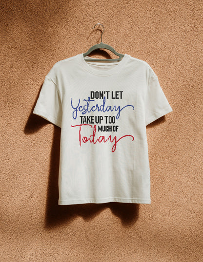 White t-shirt with motivational quote on a hanger against a brown background