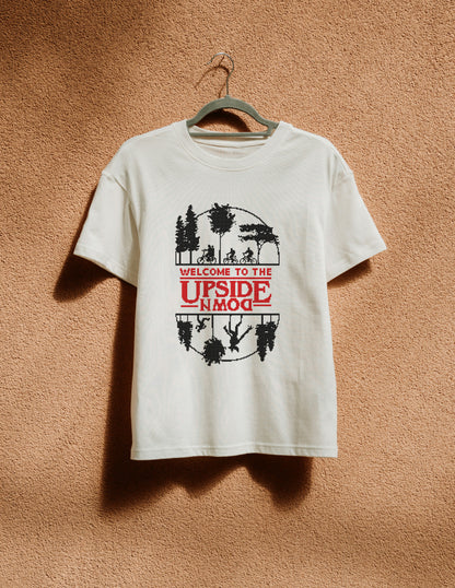 White t-shirt with graphic design on a hanger against a brown textured wall