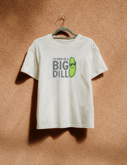 White t-shirt with pickle graphic and text on a hanger against a brown textured wall